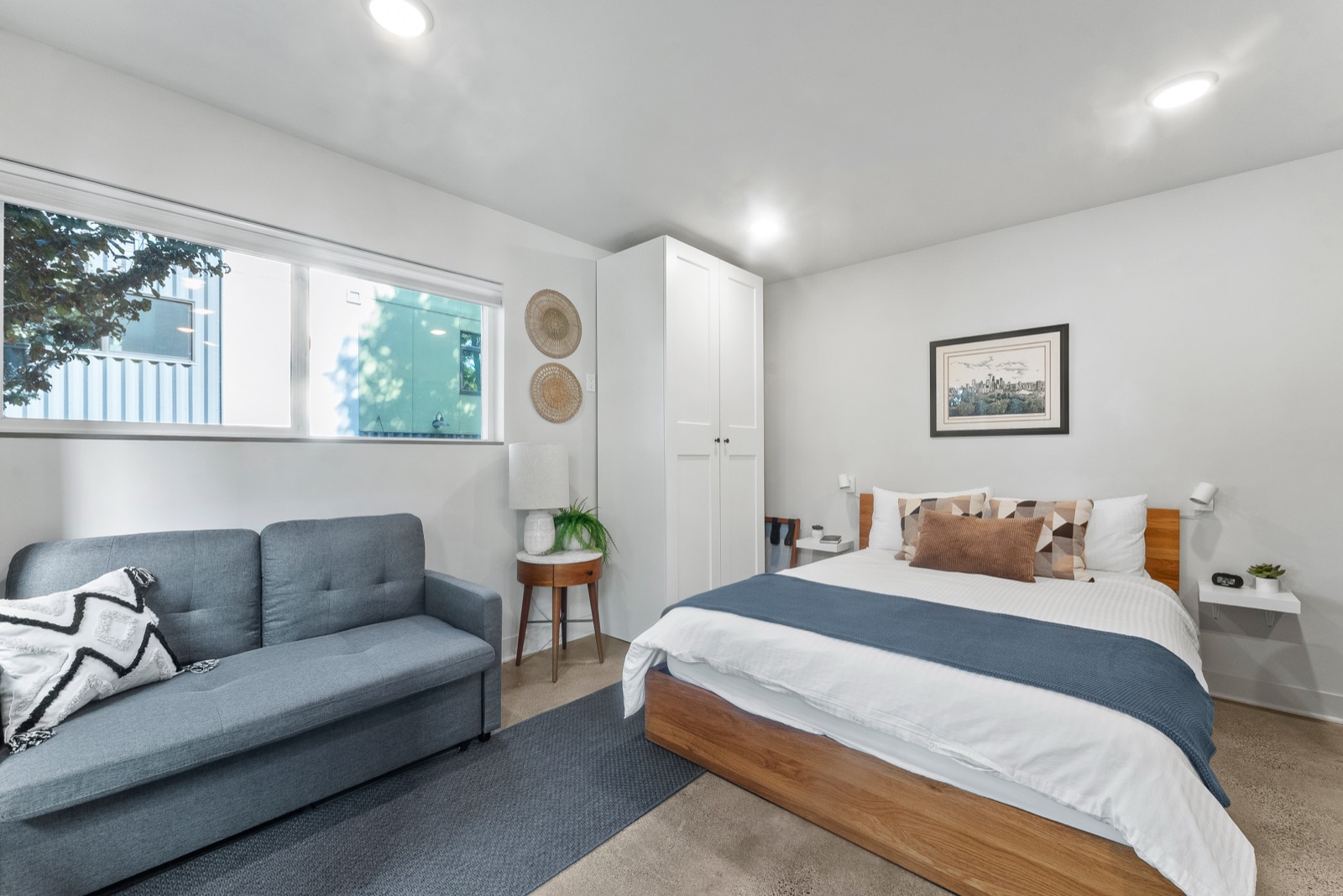 Queen bed and sofa beneath the window