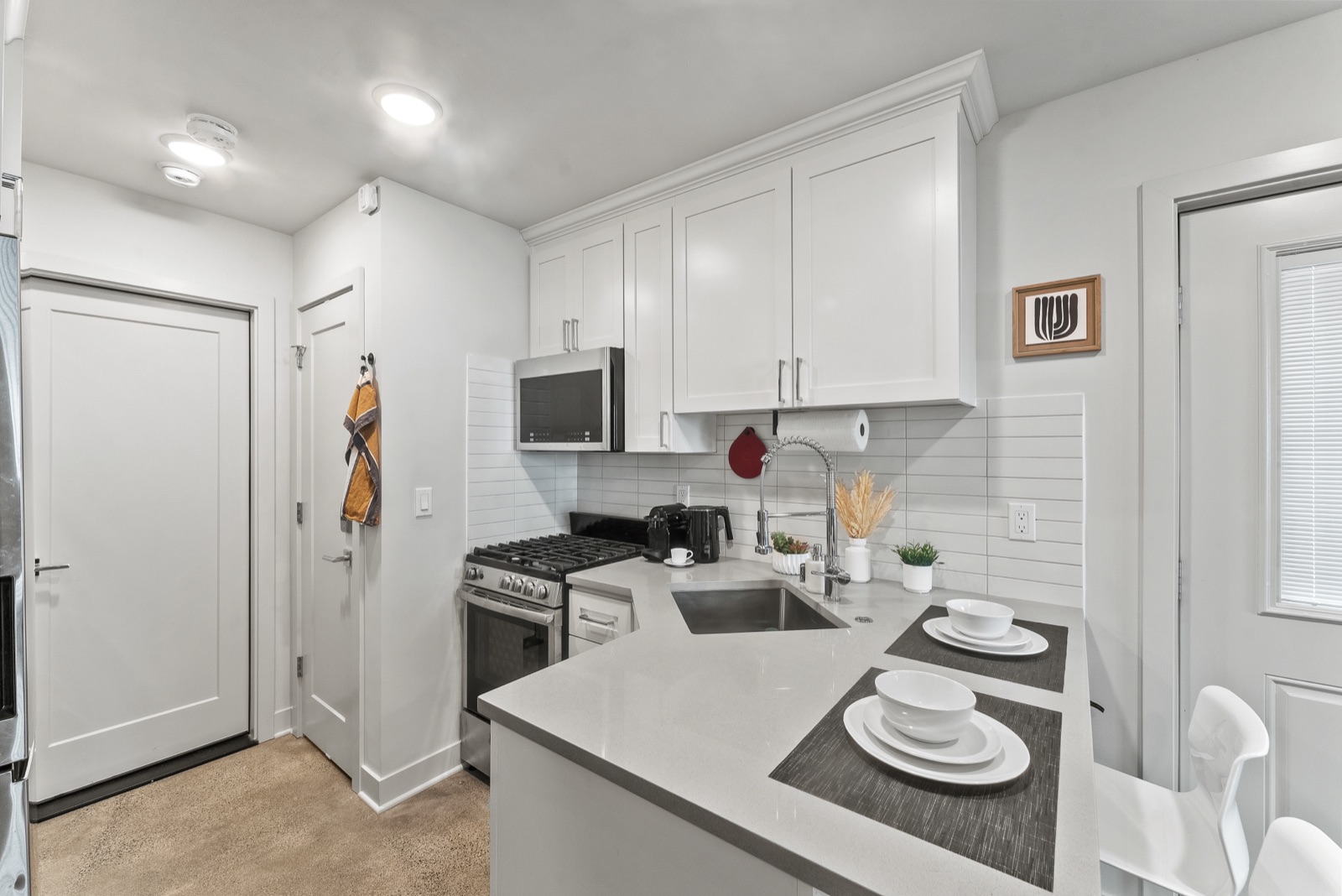 Full kitchen — gas stove, microwave, and quartz counters