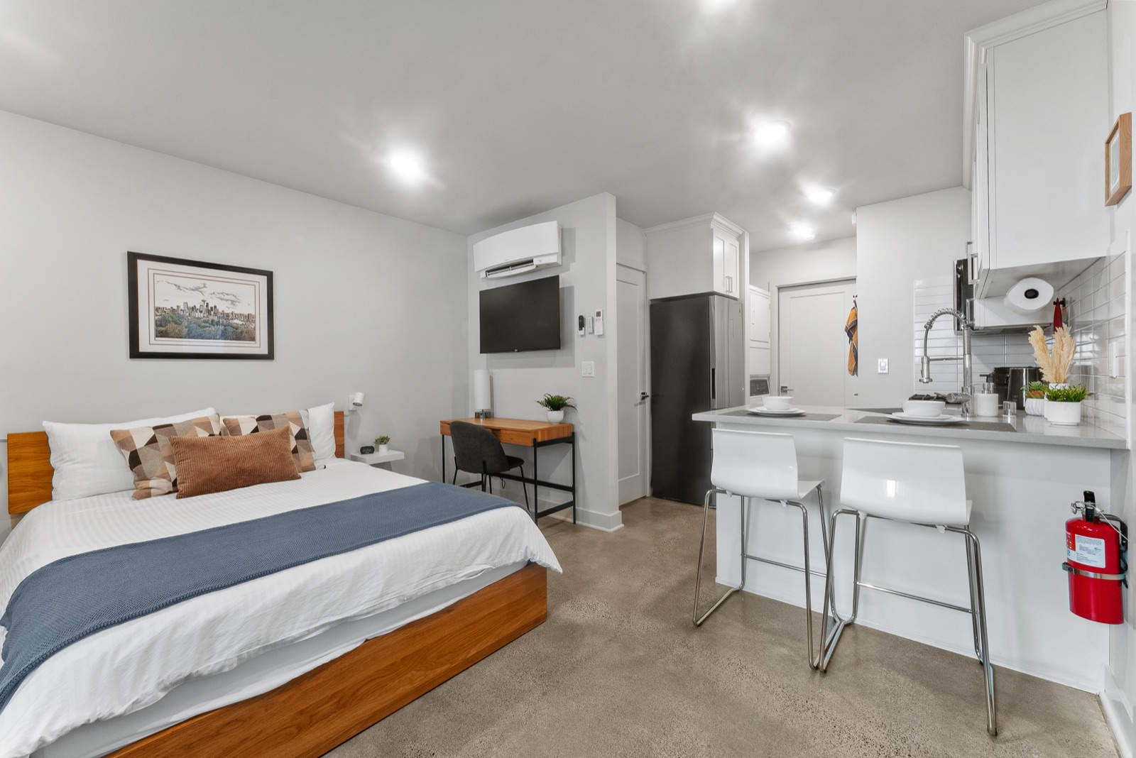 The studio — queen bed, dedicated workspace, and kitchen bar